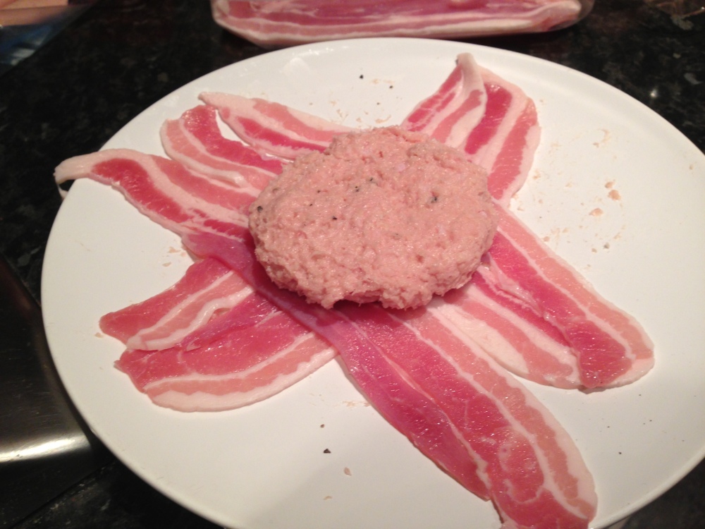 Wrap the sausage meat patty in streaky bacon