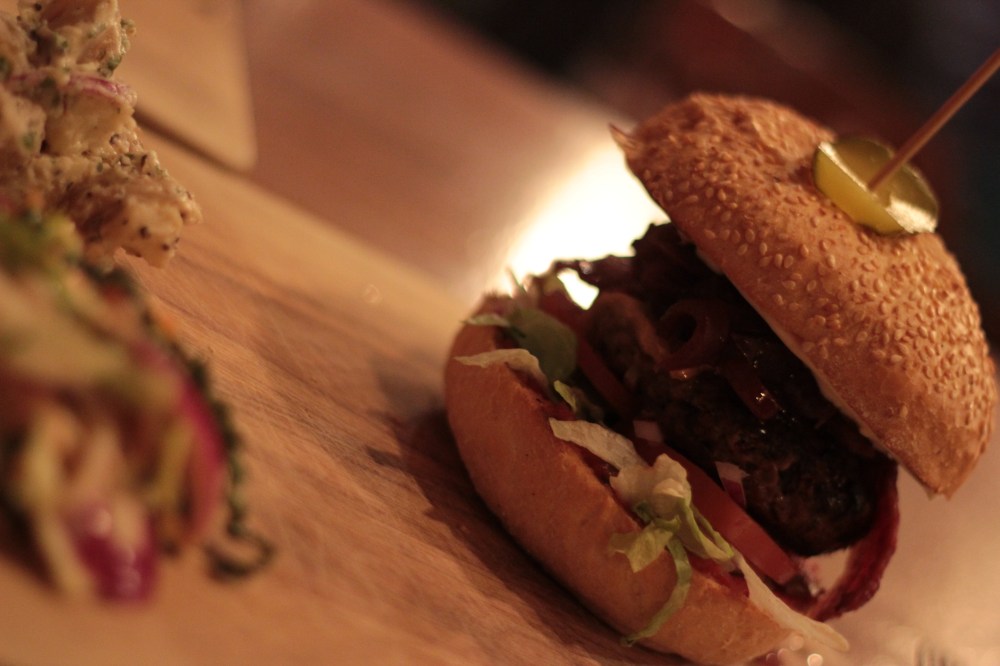 Burger topped with brie, red onion chutney and bacon