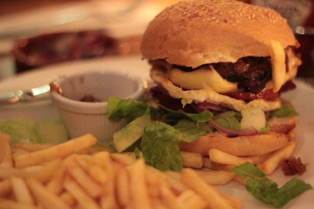 The burger came with red onion relish and fries.